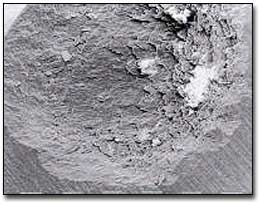 Fig. 6.-  Cráter en esmalte y dentina, inducido por un Rayo Laser de Er:YAG (330 mJ, 5 pulsos). Note las paredes rugosas y un cráter en el fondo sin cambios termales. Imagen al microscopio electrónico de barrido X 80. (Tomado de Miserendino L., Pick R.)